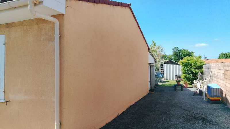 Le même pignon après nettoyage et application d'un hydrofuge, enduit revenu à sa teinte ocre